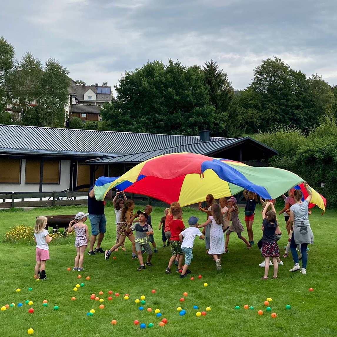 Kurz zuvor noch als Unterlage beim Sommerfest-Picknick der Kindergottesdienste Benfe, Birkelbach, Erndtebrück und Schameder genutzt, wurde das Schwungtuch dann wieder ein Mittelpunkt für das fröhliche Toben.