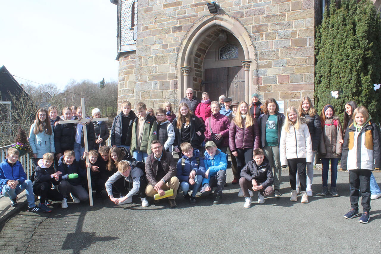 Gut 40, vor allem junge, Teilnehmende begaben sich jetzt vor der Birkelbacher Kirche bei frischem Lüftchen und Sonnenschein auf den Ökumenischen Kreuzweg.