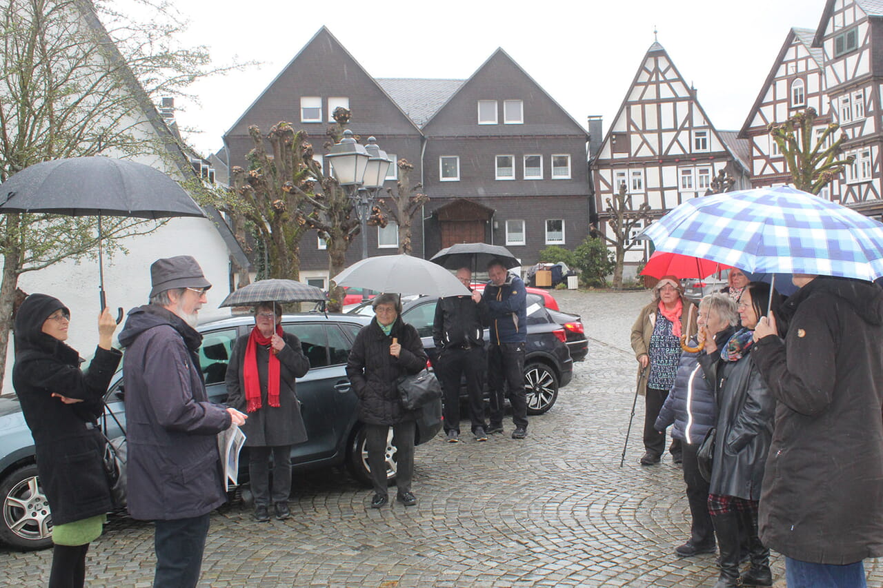 Der frühere Gemeindepfarrer Dieter Kuhli (Zweiter von links) erläuterte den Zuhörerinnen und Zuhörern auf dem Platz vor der Laaspher Stadtkirche spannende Details über das Gebäude im Speziellen und die Lahnstadt im Allgemeinen.