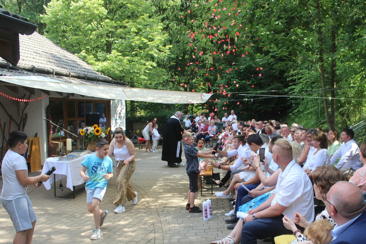 Am Ende ließen die Kinder bei Sonnenschein rote Herzen aus Konfetti-Kanonen über die Tauffest-Gemeinde bei der Siegener Erlöserkirche regnen.