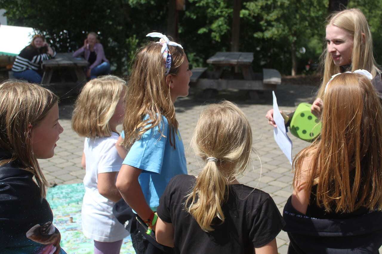 Wenn die Mädchen und Jungen beim Chaosspiel im Abenteuerdorf die passende Nummern-Karte auf dem weitläufigen Gelände gefunden hatten, forderte Anna Koch beispielsweise die Kinder einer Gruppe auf, sie mögen sich alle einen Stein suchen und gemeinsam daraus einen Turm bauen.