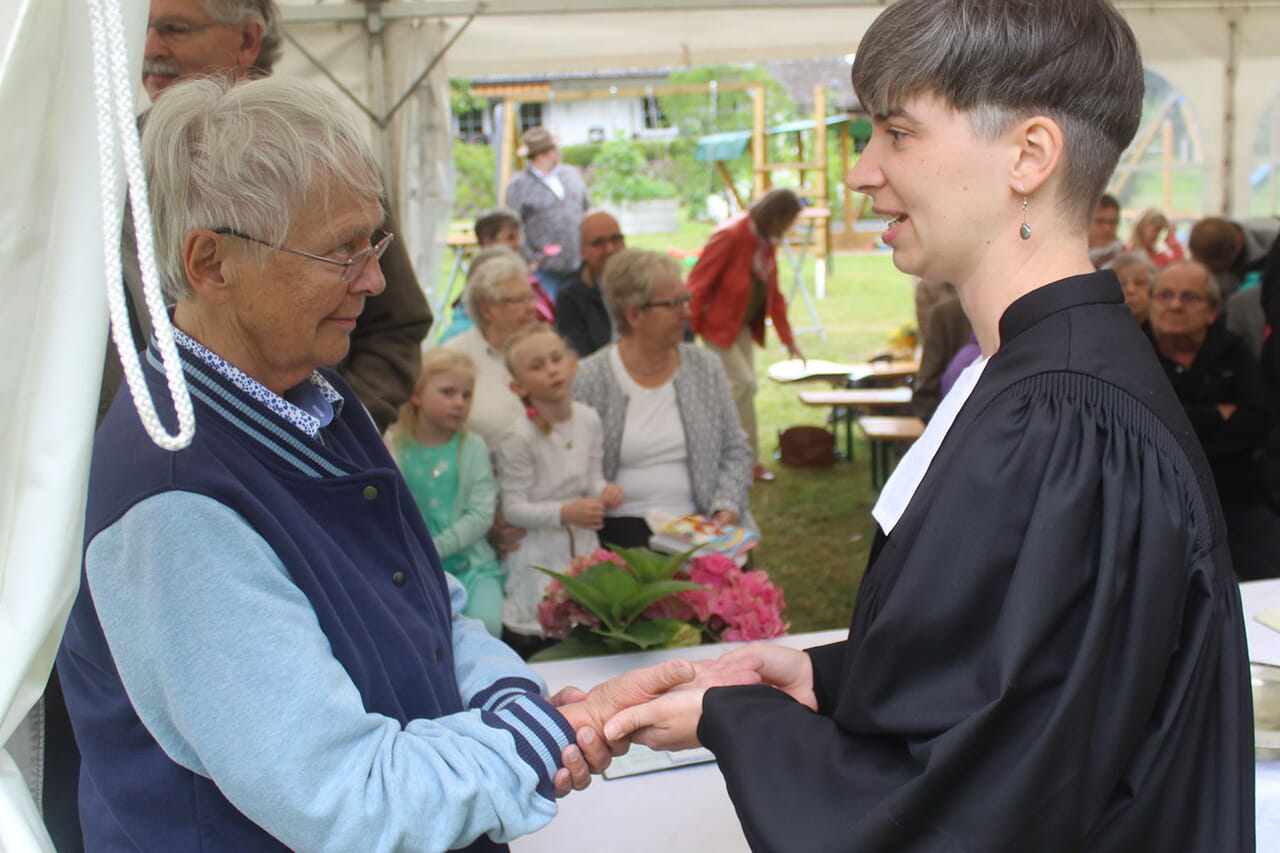 Zur Erinnerung an die eigene Taufe war die Zelt-Gemeinde eingeladen, sich von Vikarin Carmen Jäger (Foto) oder Pfarrerin Berit Nolting ein Kreuz mit dem Taufwasser aus der Eder in die Handfläche zeichnen zu lassen.