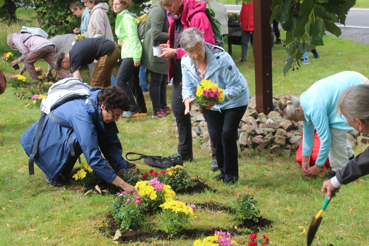 Alle Andachts-Besuchenden waren eingeladen, beim Stünzel-Kreuz Blumen zu pflanzen, hier gibt es seit den österlichen Corona-Lockdowns der Kirchen die erdigen Worte „Leben“ und „Gnade“ im Gras.